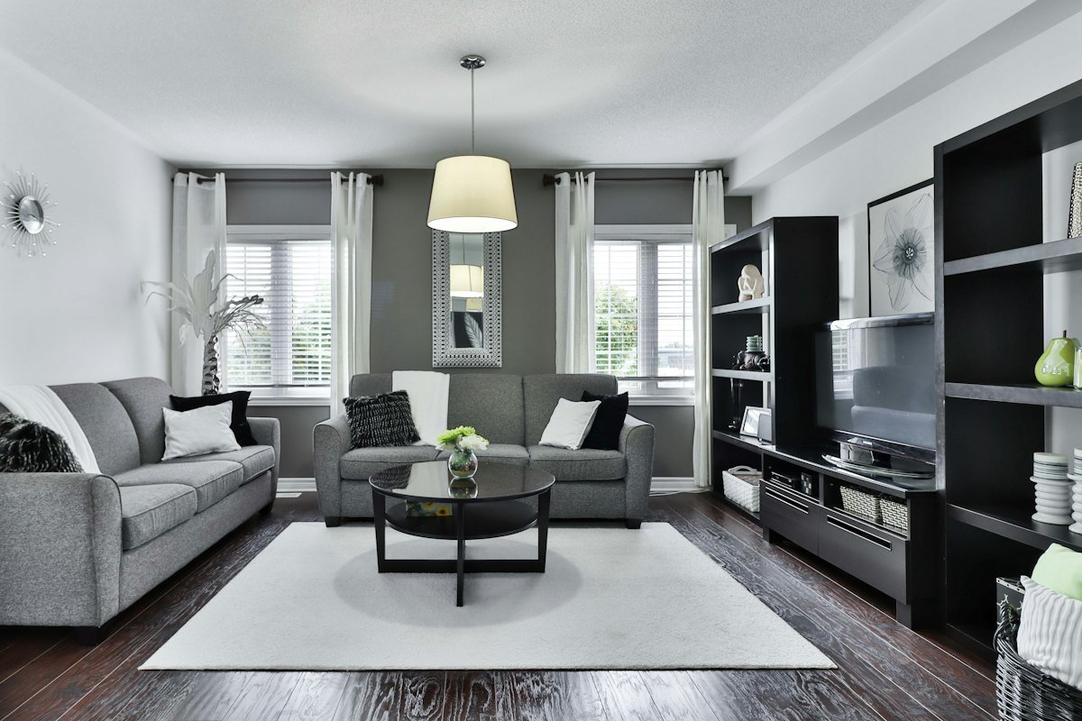 Sala con piso laminado oscuro y tapete